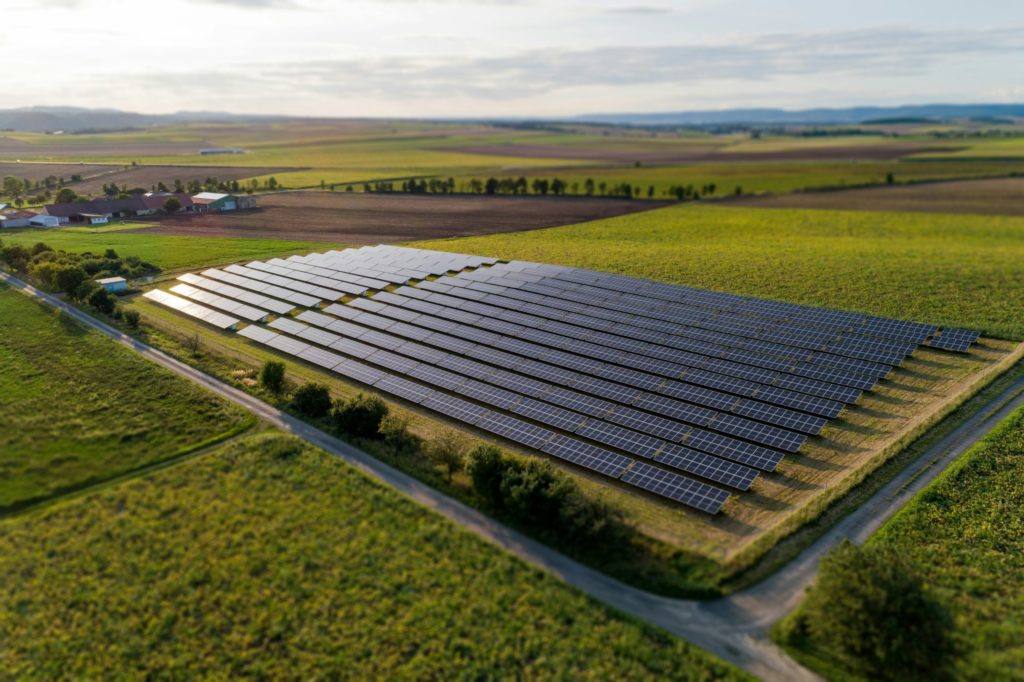 Schwarze Sonnenkollektoren auf grünem Rasenfeld